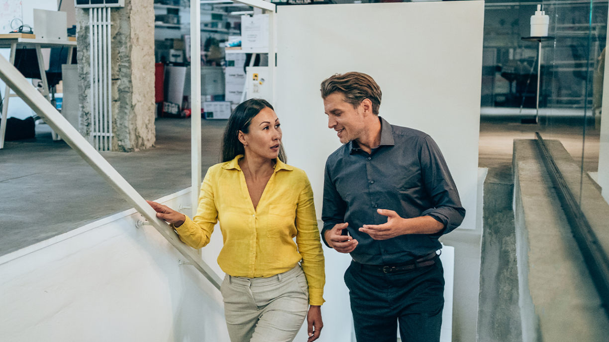 Woman and man walking up stairs in office