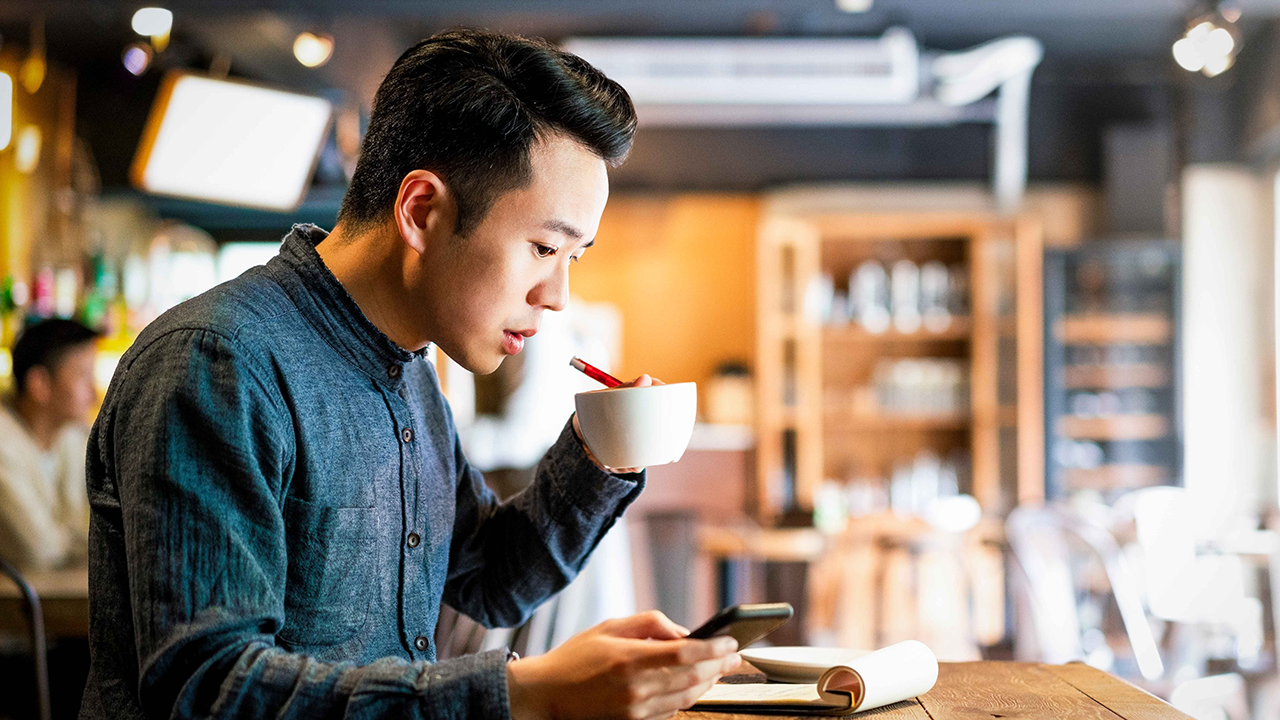 Should NFPs consider an endowment to help them with future operational support?. Businessman drinking coffee while using phone