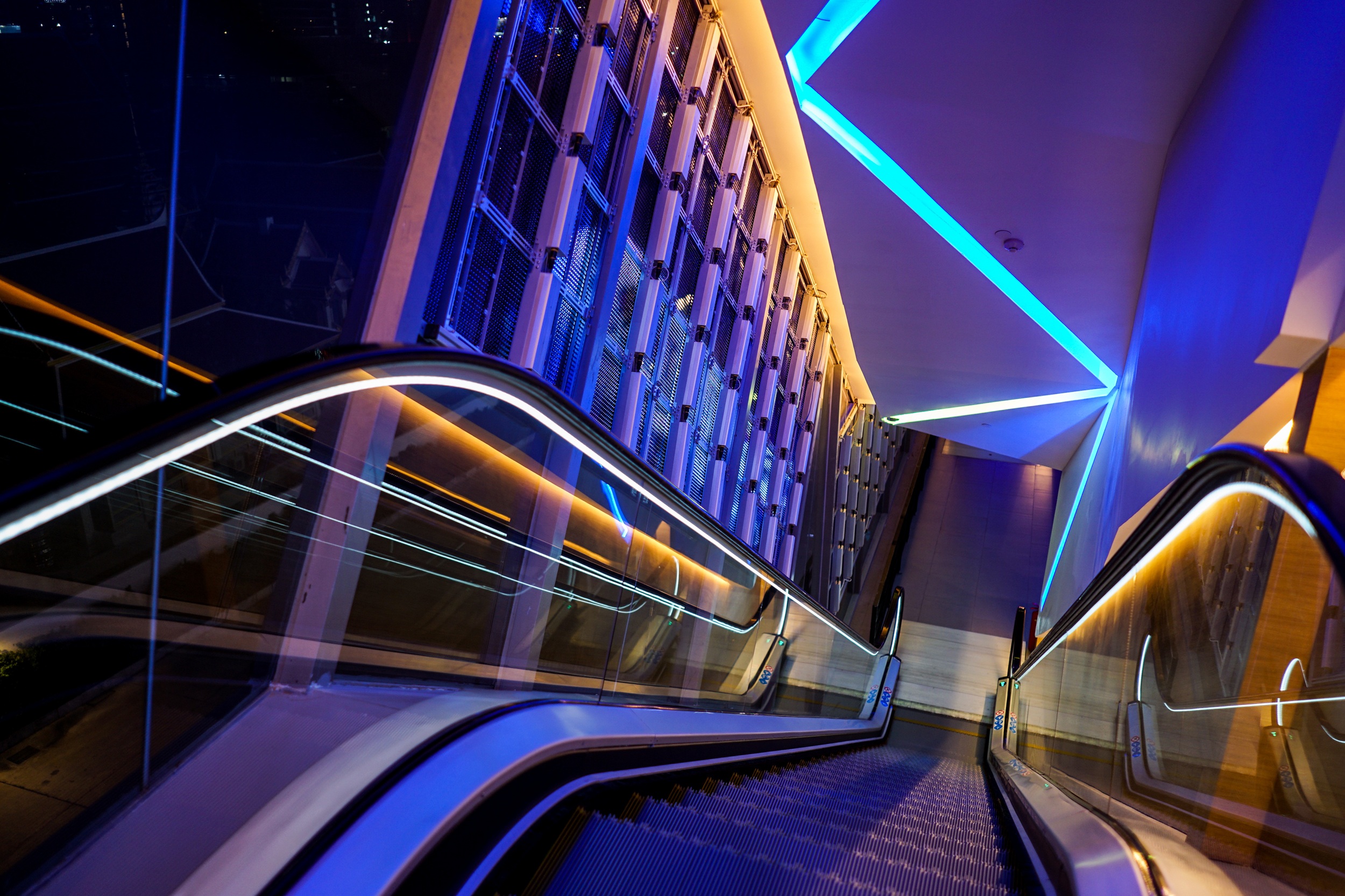 escalator with LED light beside in technology abstract neon colorful light theme.